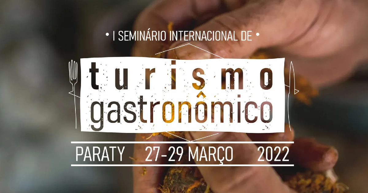 Na imagem cartaz de divulgação do Festival gastronômico de Parati por trás do cartaz uma pessoa manuseando um alimento