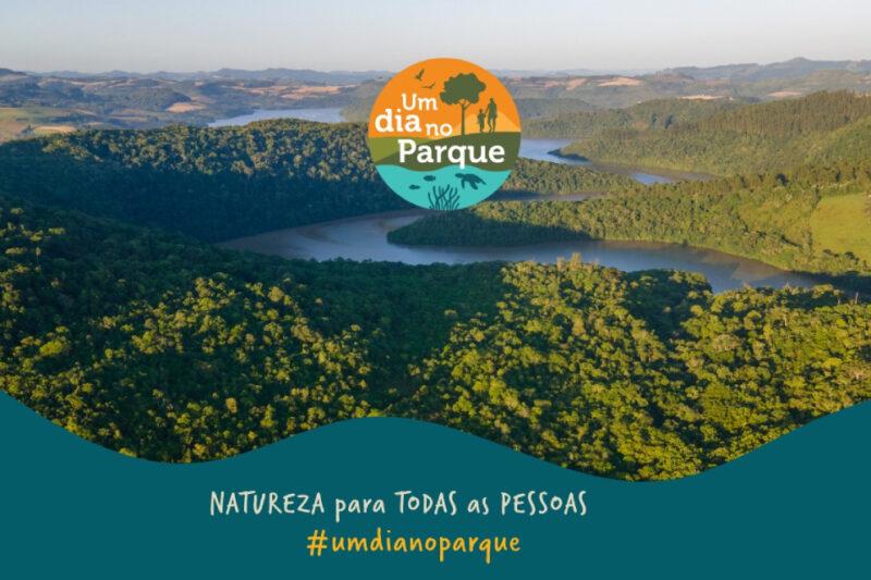 Imagem promocional do evento 'Um Dia no Parque' com uma vista aérea de um parque verdejante e um rio sinuoso. Texto: 'Natureza para TODAS as PESSOAS #umdianoparque'. Logo do evento com ícones de natureza.