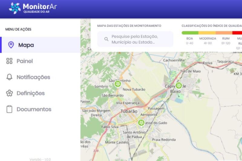 "Captura de tela da plataforma MonitorAr, exibindo um mapa interativo da qualidade do ar. O mapa mostra a cidade de Tubarão e arredores, com ícones indicando estações de monitoramento da qualidade do ar. À esquerda, há um menu com opções: Mapa, Painel, Notificações, Definições e Documentos. No topo, há uma barra de pesquisa para buscar por estações, municípios ou estados, e uma legenda colorida que classifica os índices de qualidade do ar como Boa (0-40), Moderada (41-80), Ruim (81-120) e Muito Ruim (121-200)."