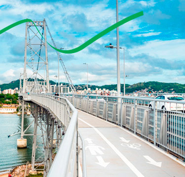 Vista da Ponte Hercílio Luz em Florianópolis, com pista de pedestres e ciclovia em primeiro plano.